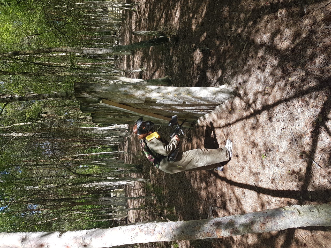 Paintball speelster zoekt dekking in het bos