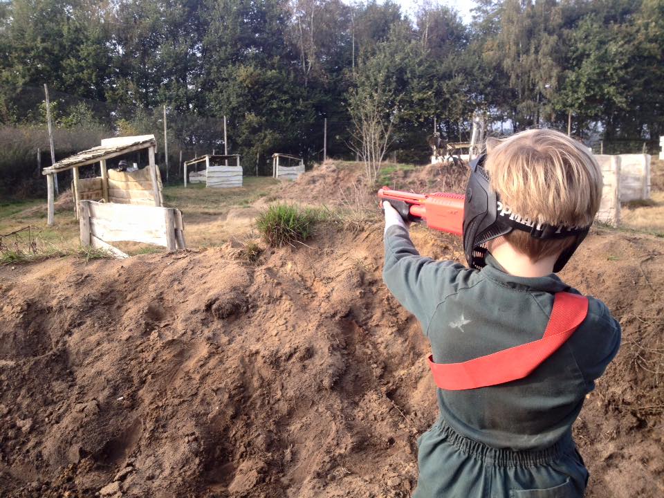 Kind richtet Paintballgun auf Gegenspieler