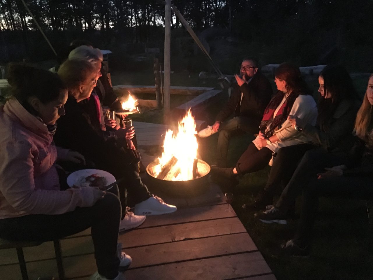 Gruppe isst und trinkt am Lagerfeuer bei Paintball Warriors Enschede
