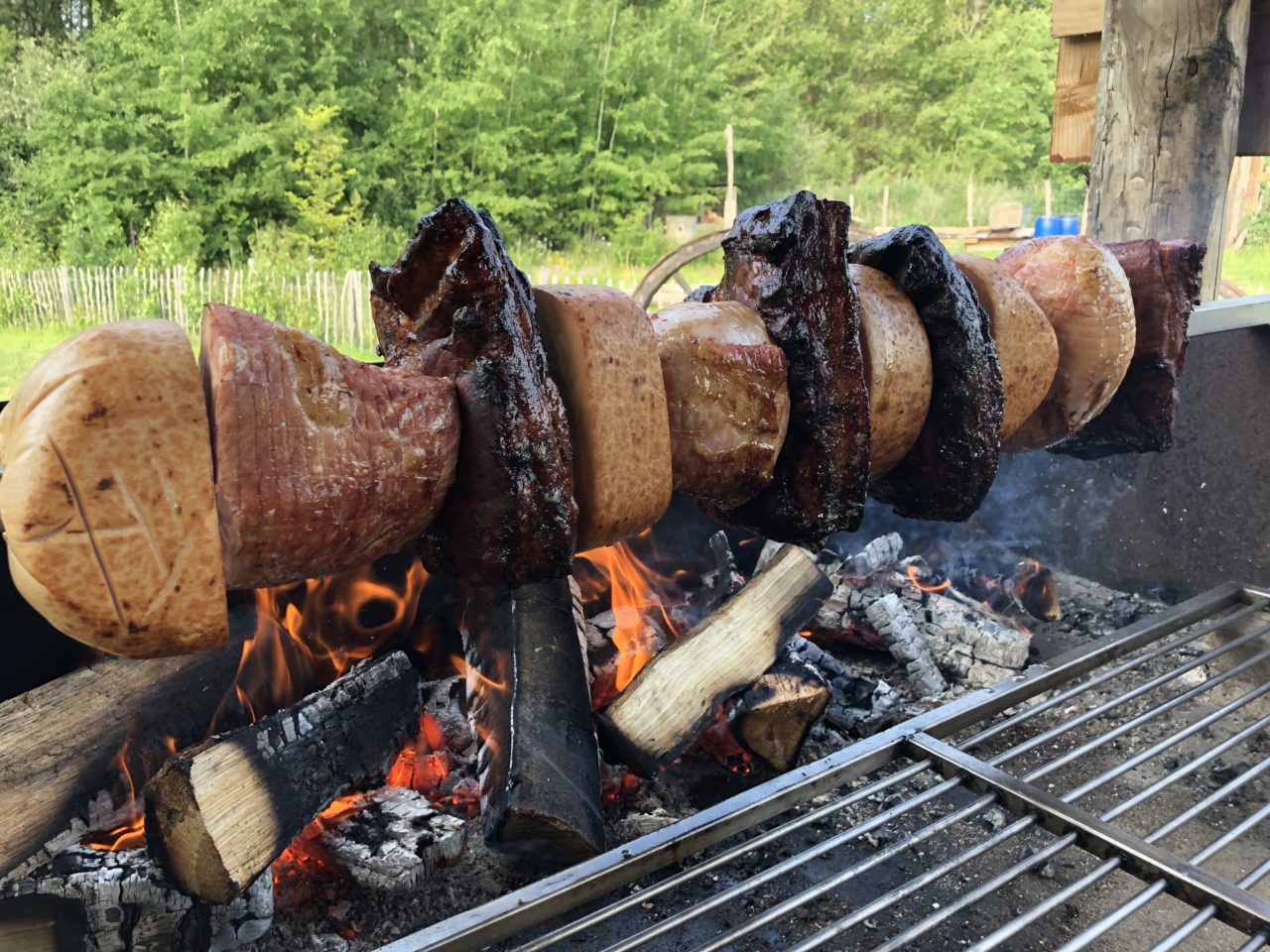 Mega Spieß mit Hähnchen, Schinken und Speck über einem offenen Feuer