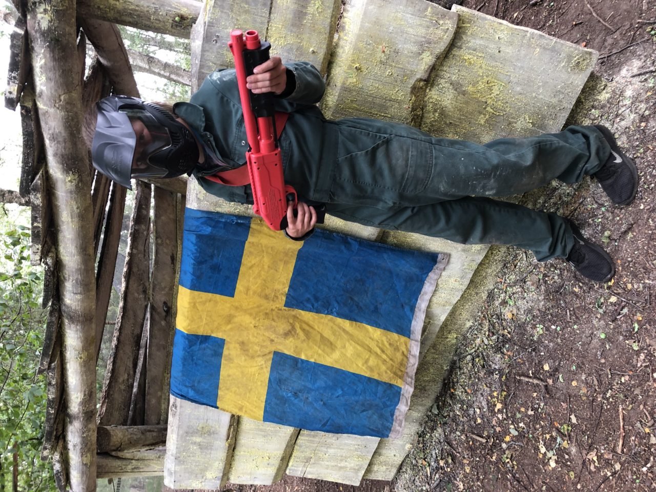 Kind staat naast vlag in kinderpaintballveld