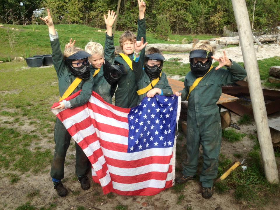 Paintballkinder halten amerikanische Flagge