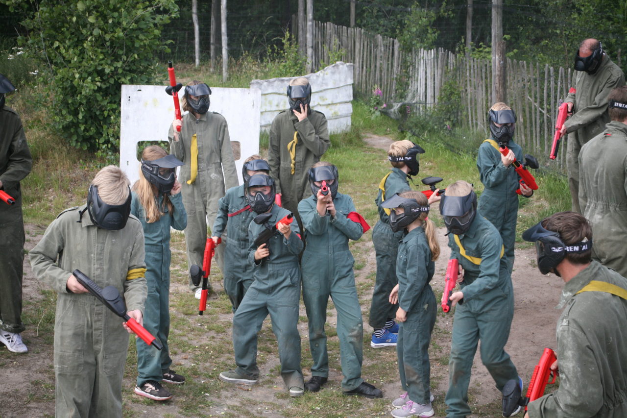 Große Gruppe von Paintballkindern, die für Foto aufwerfen